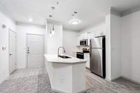 A kitchen with a white island and stainless steel appliances.
