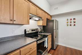 A kitchen with wooden cabinets and a black stove top oven.