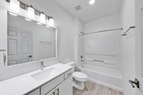 A white bathroom with a sink, toilet, and bathtub.