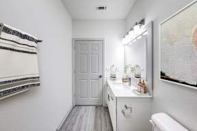 A white bathroom with a towel hanging on the wall.