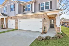 A house with a grey roof and a white garage door.