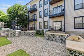 A modern apartment complex with a courtyard and a fence.