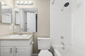 A white bathroom with a sink, toilet, and bathtub.