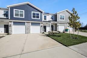 A two-story house with a garage and a driveway.