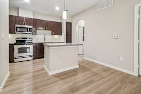 A kitchen with a white island and wooden floors.