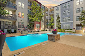A pool surrounded by apartment buildings with a "No Diving" sign.