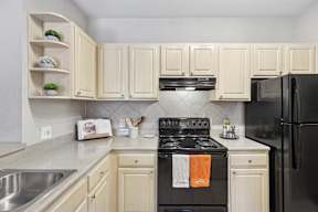 A kitchen with a black stove top oven and white cabinets.