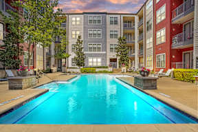 A swimming pool in front of apartment buildings.