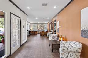 A long hallway with a bench and chairs on the right side.