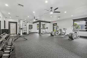 A spacious gym with a variety of equipment including treadmills, weights, and a bench press.