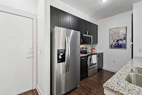 A kitchen with a granite counter top and stainless steel appliances.
