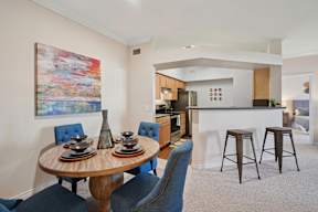 A dining room with a round table and blue chairs.