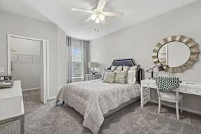 A bedroom with a bed, desk, and chair.