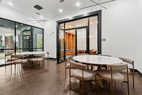 A modern dining room with a round table and chairs.