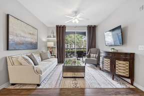 A living room with a couch, chair, and television.