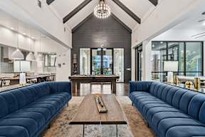 A modern living room with a long blue couch and a wooden coffee table.