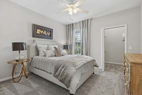 A bedroom with a large bed and a ceiling fan.