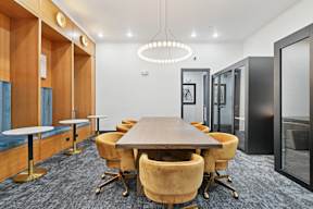 A conference room with a long table surrounded by chairs.