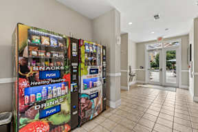 A vending machine selling snacks and drinks in a hallway.