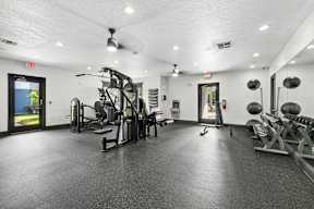 A gym with a variety of equipment including weights and a treadmill.