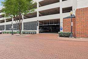 A parking garage with a tree in front of it.