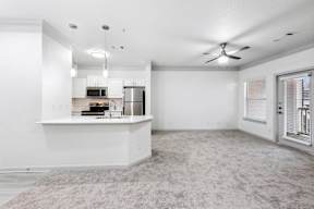 A spacious kitchen with white cabinets and a countertop.