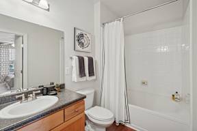 A bathroom with a white toilet, sink, and bathtub.