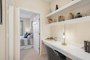 A white desk with a lamp and books on it.