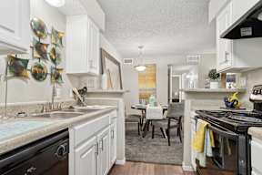A kitchen with white cabinets and a black stove top oven.
