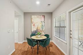 A dining room with a table and chairs.