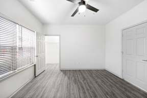 A room with a ceiling fan and a door.