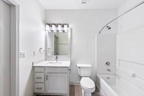 A white bathroom with a sink, toilet, and bathtub.
