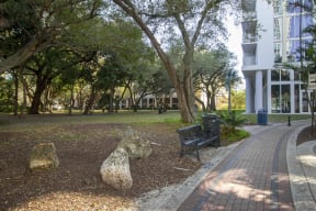a park with trees and a bench in front of a building