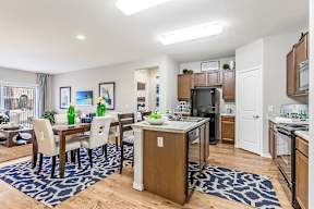 A kitchen and dining area with a table set for two.