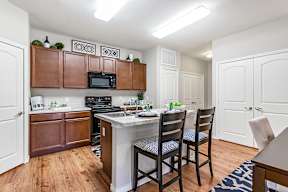 A kitchen with a white counter top and brown cabinets.