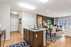 A kitchen with a wooden island and a dining table with chairs.