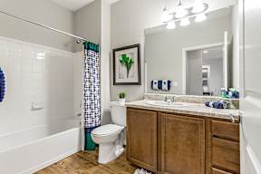 A bathroom with a toilet, sink, and shower.