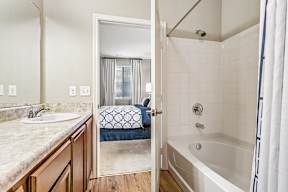 A bathroom with a white tub and a sink.