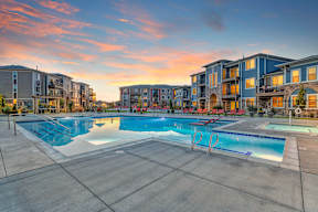 A large swimming pool surrounded by apartment buildings.