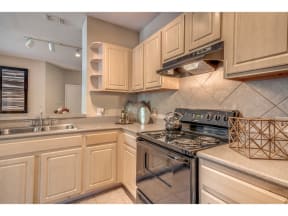 a kitchen with ivory cabinets and a stove and a sink