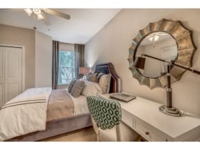 a bedroom with a bed and a mirror on the wall