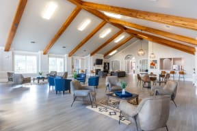 a large living room with high ceilings and chairs and tables