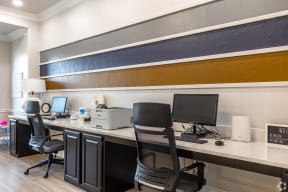 an office with a desk with two computers and a printer