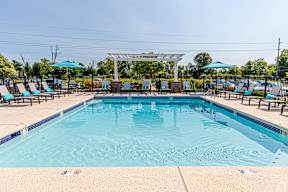 A large outdoor swimming pool with a clear blue sky above.