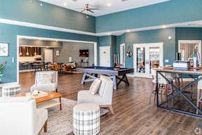 A living room with a pool table and a bar area.