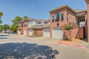 A row of houses with garages and driveways.