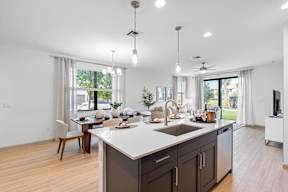 a kitchen with an island and a dining room with a table and chairs