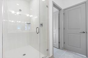 a white bathroom with a shower and a door