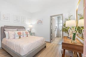a bedroom with a bed and a dresser and a mirror