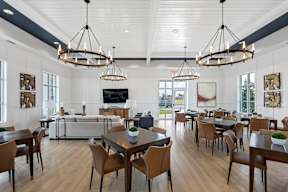 the dining room and living room of a home with white walls and wood flooring